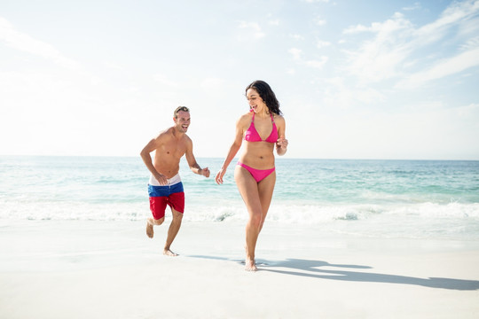 在沙滩上奔跑的情侣