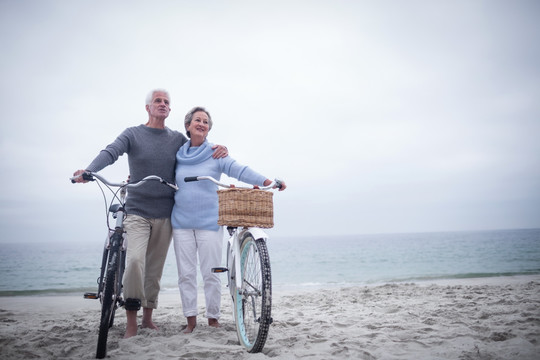 在海边推着自行车的老夫妇