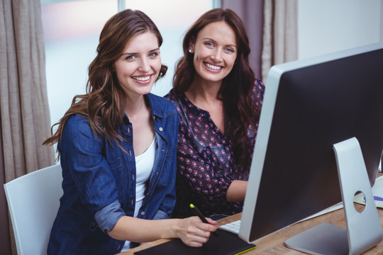坐在电脑前工作的两个女人