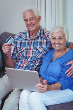 微笑着使用电脑网购的老夫妇
