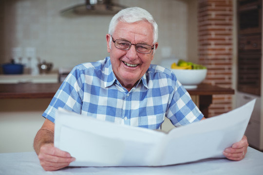 微笑的老人在看报纸