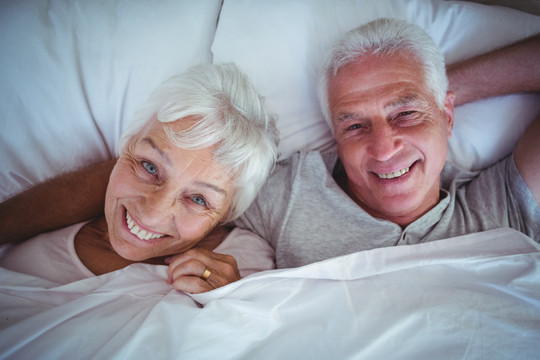 微笑的老夫妇躺在床上