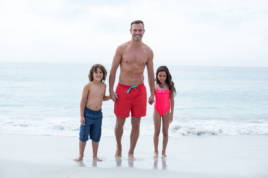 站在海滩上的父亲和孩子