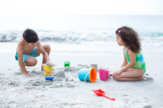 在海滩上玩沙子的孩子们