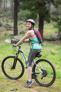 在树林里骑自行车的女人
