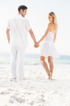夫妇在海滩上牵着手