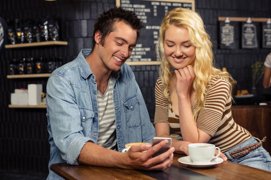 在咖啡屋里使用手机的夫妇