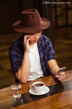 在咖啡馆里使用手机的男人