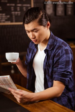 在咖啡馆里喝咖啡看报纸的男人