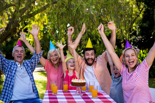 一家人举起双臂在院子里过生日
