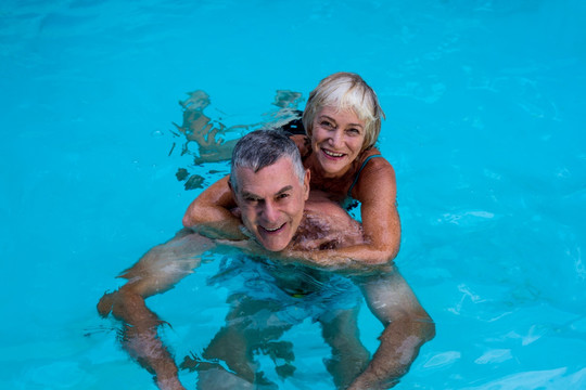老年夫妇在游泳池里游泳