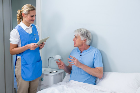 护士拿着平板电脑和病人交谈