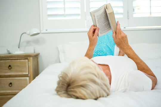 躺在床上看书的老太太