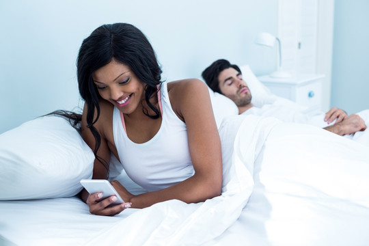 女人在丈夫睡着时偷看她的手机
