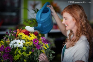 在给花卉浇水的女人