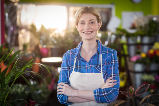 抱着双臂的女人在花店里