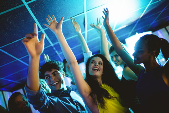一群微笑的朋友在酒吧里跳舞