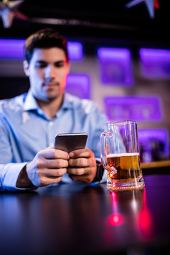 在酒吧里使用手机的男人