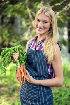 微笑的女农民拿着胡萝卜