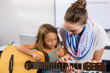 在教女学生弹吉他的女老师