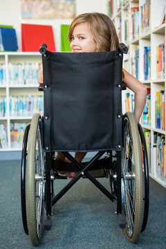 坐在轮椅上在图书馆找书的小学生