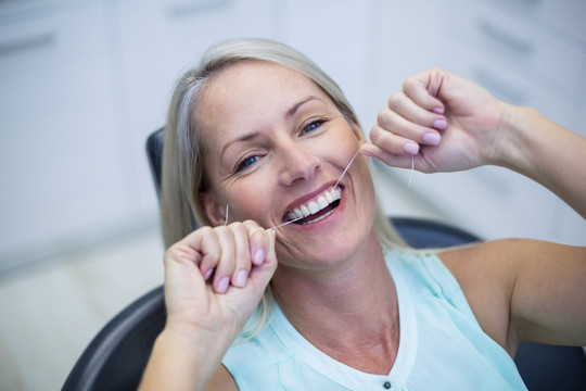 女人用牙线清洁牙齿