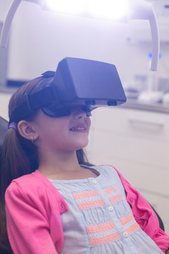 坐在牙科椅上戴着虚拟耳机的病人