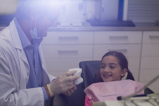 牙医向病人展示牙齿模型