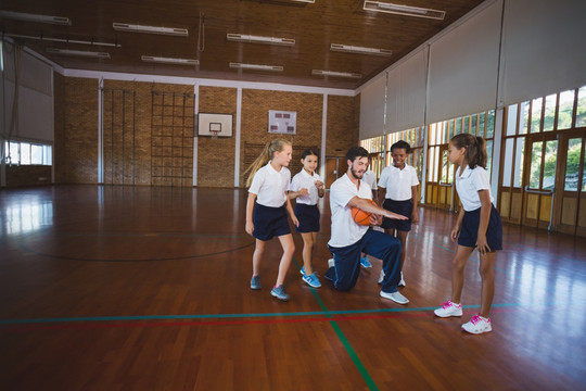 体育老师在教学生们打篮球