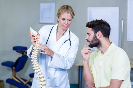 物理治疗师对患者脊柱模型解释