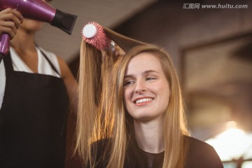 在美发店吹头发的女人