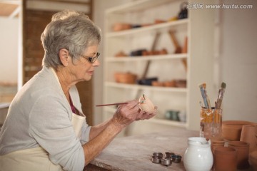 在陶器碗上绘画的老太太