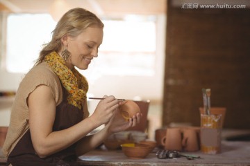 在陶器上绘画的女陶艺工