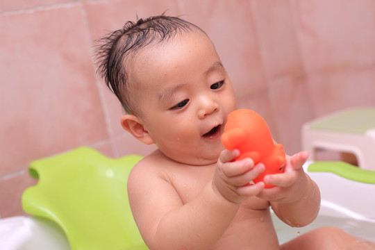 婴儿澡盆里自己开心玩耍的男宝宝