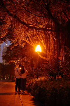 路灯下的一对情侣在拍照互动