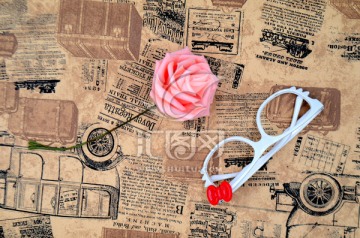 旧报纸上的眼镜和玫瑰花