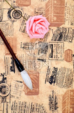 旧报纸上的毛笔和玫瑰花