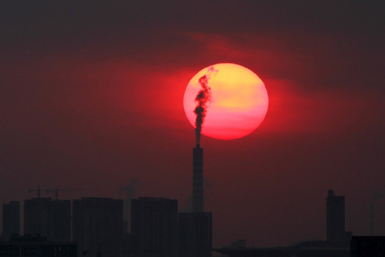 夕阳暮色下的烟囱和高楼