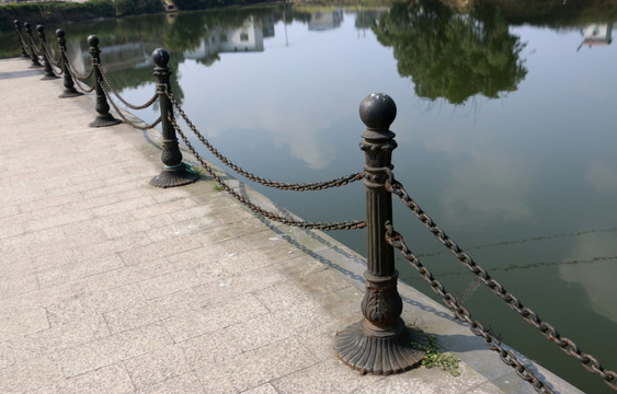 清澈湖水倒影着古老铁艺栏杆