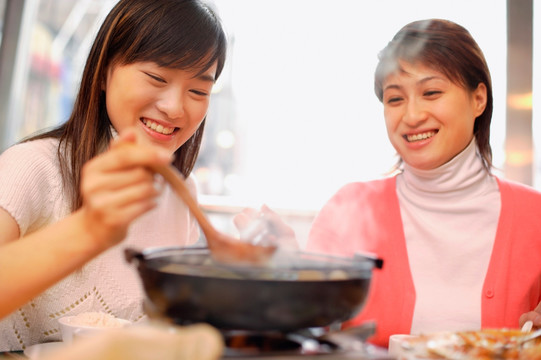 在餐馆里喝汤的年轻妇女