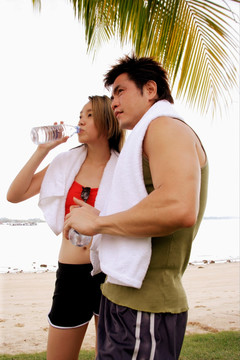 在海边喝水的夫妇