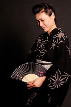 穿着日本服装的女子拿着扇子