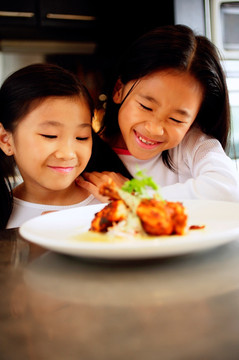 两个孩子看着盘子里的食物