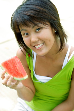 微笑的女人拿着一片西瓜