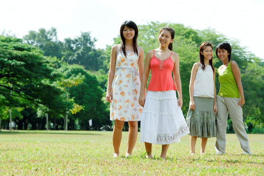 年轻女子肩并肩站在田野里