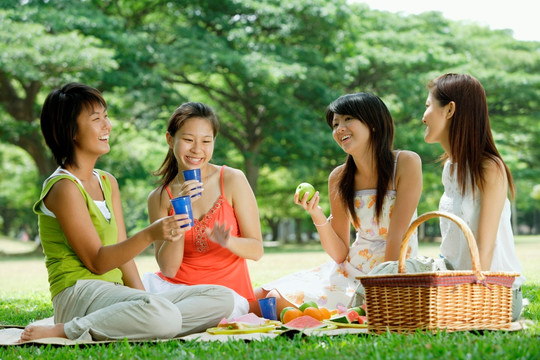 年轻女子坐在公园里野餐
