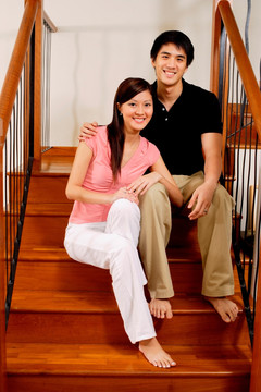 微笑着坐在楼梯上的夫妇