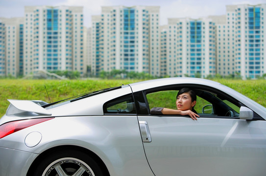 女子坐在银色跑车