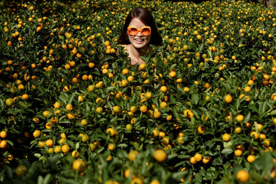 站在柑橘植物中的年轻女子