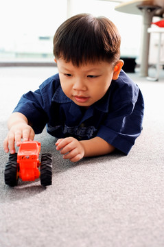 小男孩玩玩具拖拉机